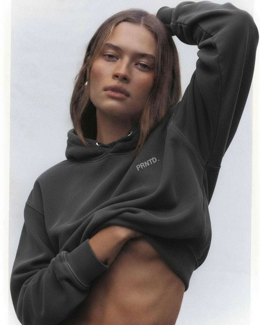 Person wearing a black hoodie with 'PRTND' branding on a light gray background